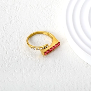 Detail of gold geometric ring with red emerald-cut stones and white zircon accents