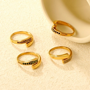 Detailed shot of four gold-plated wrap rings featuring purple, black, and emerald zircons