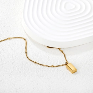 Polished gold rectangular bar pendant necklace on elegant white beaded chain
