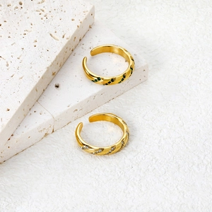 Detail of gold bamboo style rings with emerald green and clear zircon stones