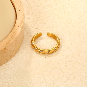 Detail of vintage gold bamboo ring with emerald zircons on a textured stone base