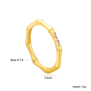 Detail of bamboo shaped golden stainless steel ring with four pink gemstones on white back