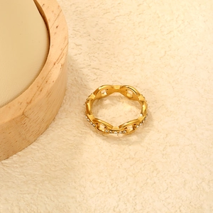 Detailed close-up of gold chain link ring with white cubic zirconia pavé setting