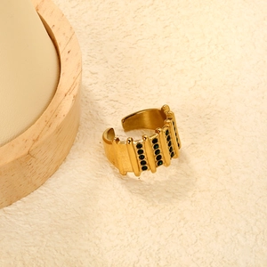 Detailed macro of gold bamboo style ring with rows of small green zircon stones