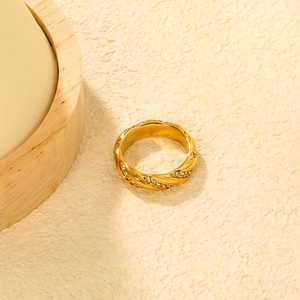 Macro shot of 18K gold plated twisted rope ring with emerald white zircon stones