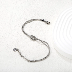 Detail of double-layer stainless steel snake chain bracelet with center knot design
