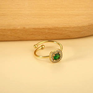Vue macro d'une bague ajustable dorée avec émeraude carrée et zircons scintillants