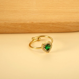 Vue macro d'une bague ajustable dorée avec émeraude cœur et petits diamants blancs