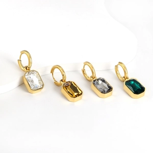 Close-up of four rectangular crystal pendants in white, amber, black, and emerald green