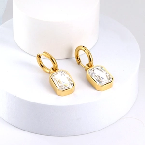 Detail of 18K gold plated hoop earrings featuring large emerald cut cubic zirconia crystals