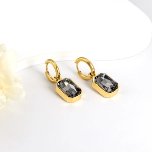 Detail of gold-plated rectangular drop earrings with dark grey step-cut crystals