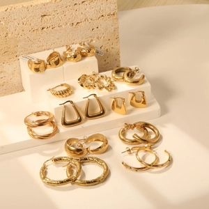 Boucles d'oreilles dorées géométriques torsadées en C en acier inoxydable sur présentoir