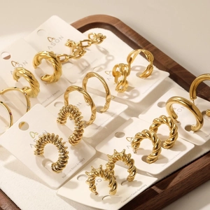 Assortiment de boucles d'oreilles créoles dorées en acier inoxydable sur un plateau