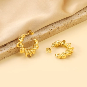 Boucles d'oreilles dorées torsadées en forme de C avec un style poli irrégulier
