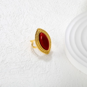 Vintage gold marquise ring with red stone inlay on a minimalist white display stand