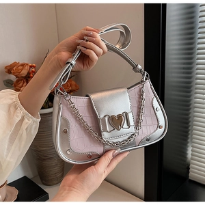 Detail of silver and pink crocodile embossed bag with heart buckle and metal studs