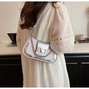 Macro detail of pink crocodile texture underarm bag with silver heart buckle and chain