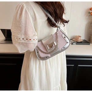Detailed shot of pink crocodile pattern underarm bag with silver heart buckle and chain