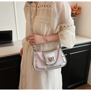 Detail of pink crocodile pattern leather bag with silver heart buckle and chain