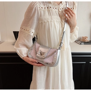 Detail of pink crocodile embossed leather bag with silver heart buckle and chain