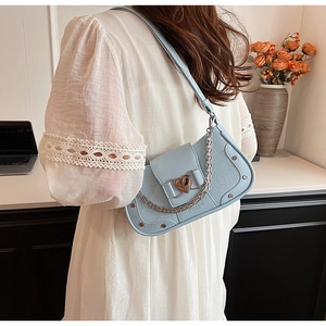 Close-up of light blue crocodile texture shoulder bag with silver heart-shaped buckle