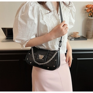 Black crocodile-embossed underarm bag with heart metal lock and chain on model