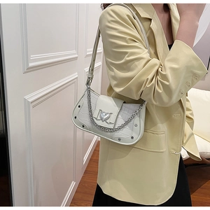 Detailed view of white crocodile texture underarm bag with silver heart buckle and chain