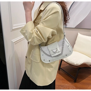 Detail of white crocodile texture baguette bag with silver heart buckle and chain