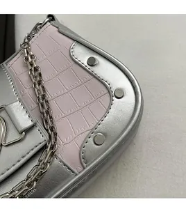 Detail of silver metallic and pink croc-effect leather with rivets and chunky chain