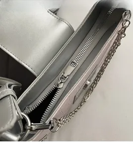 Close-up of smooth metal zipper and embossed texture on silver shoulder bag