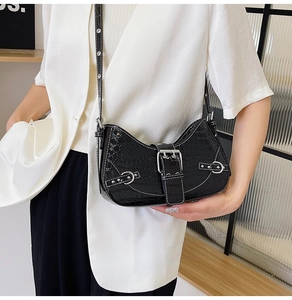 Détail du sac bandoulière noir motif crocodile avec boucle argentée et bandoulière en cuir