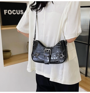 Détail d'un sac sous les aisselles à motif crocodile noir avec boucle argentée élégante