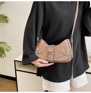 Détail du sac sous le bras marron clair à motif crocodile avec boucle argentée et bandoulière