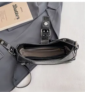Vue détaillée du sac en cuir noir motif crocodile avec compartiments internes séparés