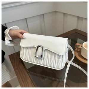 Detail of white square bag with wavy quilting and silver U-shaped metal buckle finish