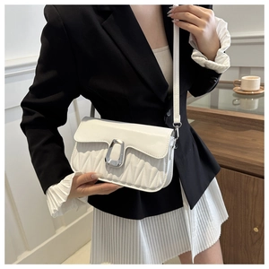 Close-up of white quilted leather crossbody bag with silver U-shaped metal buckle detail