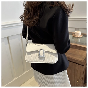 Close-up of white pleated crossbody bag with silver U-shaped buckle on a model
