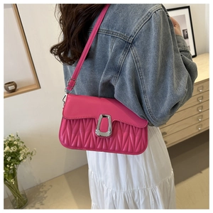 Detail of hot pink shoulder bag featuring pleated PU leather and silver U-shaped buckle