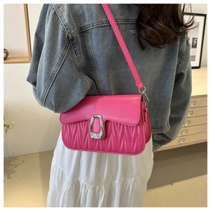 Hot pink pleated leather shoulder bag with a silver horseshoe buckle shown on a model