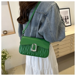 Close-up of green pleated leather bag with silver U-shaped buckle and adjustable strap