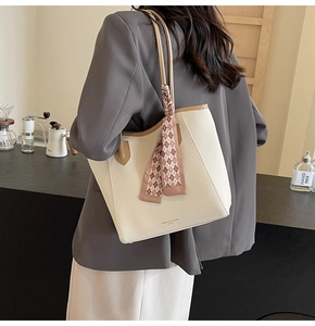 Detail of off-white tote bag with lychee texture and decorative silk scarf handle