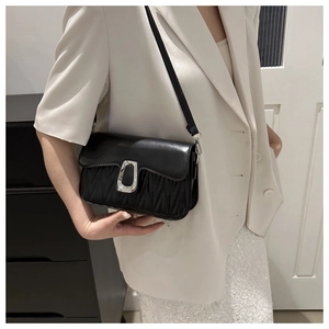 Detail of black matelassé leather shoulder bag with large silver U-shaped metal buckle