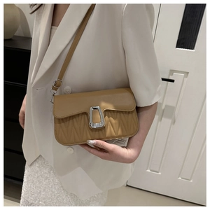 Close-up of caramel leather shoulder bag with V-quilted texture and silver buckle