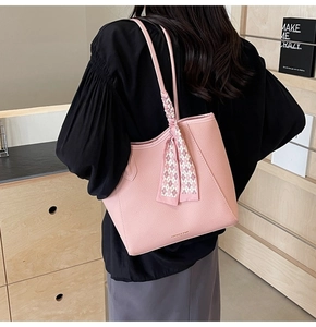 Pink lychee grain leather tote bag with elegant silk scarf shown on model shoulder