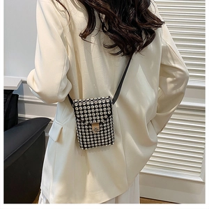 Mini borsa per telefono con strass e chiusura dorata su modella in blazer