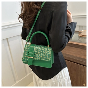 Detail of emerald green faux crocodile texture handbag with metallic square buckle