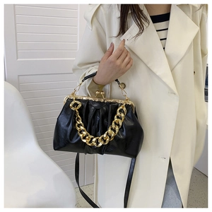 Close-up of black pleated faux leather bag with vintage gold metal frame and chain strap