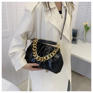 Detail of vintage black pleated leather crossbody bag with chunky gold metal chain on model