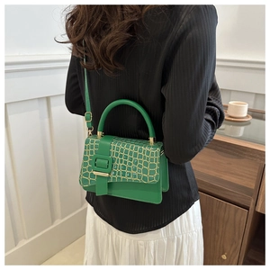 Chic green stone pattern small square handbag worn by model in casual interior setting