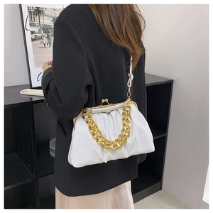 White pleated cloud bag with chunky gold chain detail worn over black suit